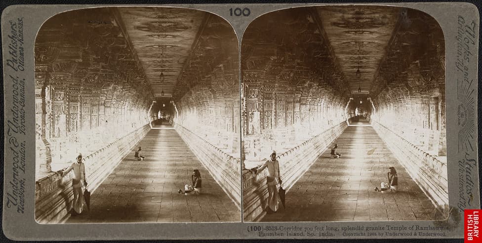 A sepia stereograph card with two near-identical photographs side by side, each showing a long, straight pillared corridor receding to a bright doorway, with a man standing at left and two figures seated on the floor.